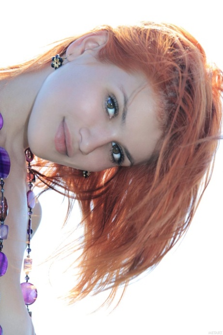 Redheaded babe Violla A poses completely naked among the purple flowers