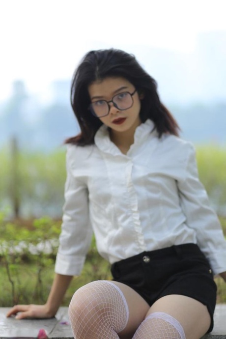 Dark-haired Asian model Irina posing in her lovely outfit outdoors