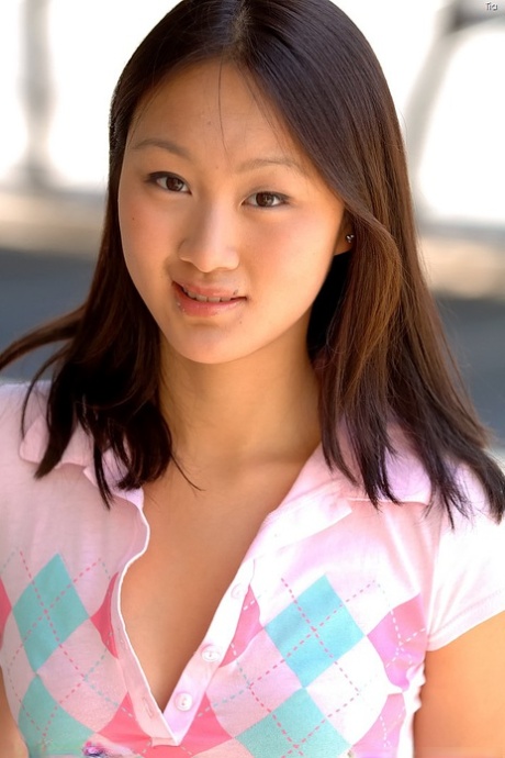 Asian honey with a pierced belly Tia reveals her tiny tits outdoors